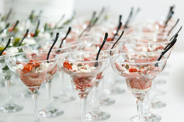 Rows of gourmet beef appetizer cups served in cocktail glasses at a catered event, showcasing elegant presentation for a formal reception.