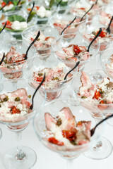 Multiple glasses filled with gourmet beef and vegetable appetizers prepared for a catered event, emphasizing elegant banquet service.