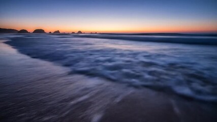 A serene late evening moment captured as ocean waves blur across a sandy beach under a twilight sky - Powered by Adobe