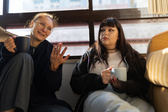 Women friends drinking coffee having relaxing conversation - Powered by Adobe