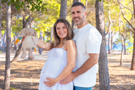 Peaceful woman relaxing with rainbow flag near marina at sunset in the city. Freedom, diversity, identity, equality and pride concept with urban background and soft golden light.