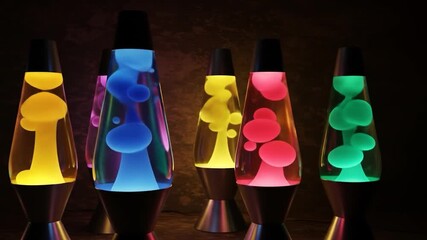 Multiple colorful lava lamps glow with hypnotic wax formations in a dark room