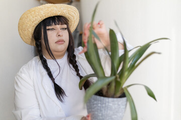 Young woman caring for houseplant at home