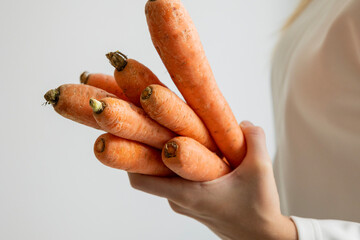 kid hands holding fresh bunch of carrots, healthy eating concept, close up