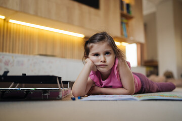 serene young woman gazing upward, thoughtful caucasian female relaxing on floor with gentle light
