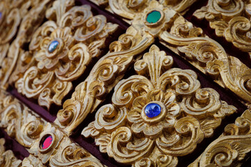 Golden Lanna-style Thai pattern panels decorated with gems for luxurious architecture and decoration.