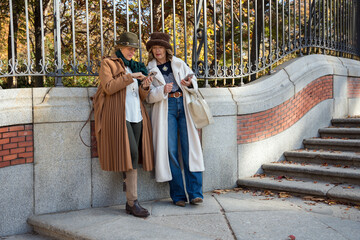 Stylish friends exploring a vibrant park during autumn's golden hues