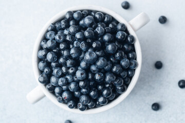 Blueberries in white bowl with soft cloth for comfort, diet or organic eating concept