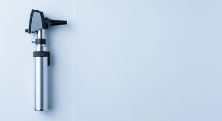 Otoscope on light blue background, a medical instrument for ear examination. Healthcare and diagnostic tool for ENT specialist.