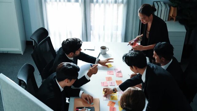Top view of business people brainstorm idea by using sticky notes while planning marketing strategy at meeting room. Group of diverse team discuss about financial plan. Teamwork concept. Directorate. - Powered by Adobe