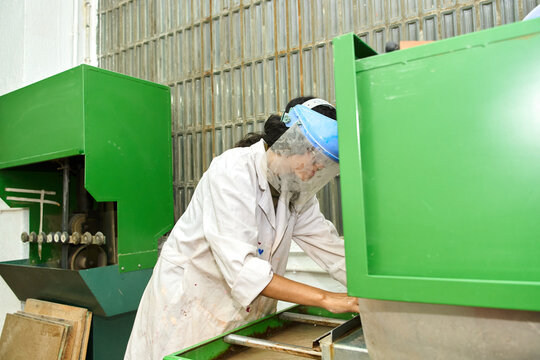 Woman working with machinery wearing safety equipment