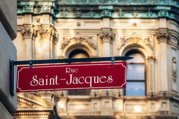 Street sign of Rue Saint-Jacques in downtown Montreal with historic architecture in soft evening...