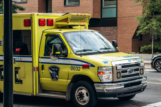 Montreal, Canada - August 13, 2025: yellow ambulance (Urgences-sante) on downtown street, Quebec emblem visible