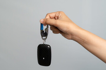 Hand Holding A Modern Car Key Fob With Carbon Fiber Design