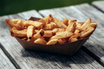 Fresh french fries in a paper tray outdoors