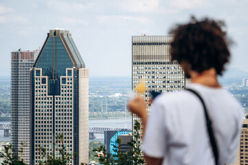 Montreal, Canada - 15 August 2025: View of downtown skyscrapers from Kondiaronk Belvedere with a person in the foreground
