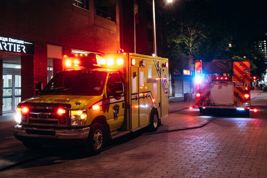 Montreal, Canada - August 15, 2025: Emergency ambulance and fire truck with flashing lights in downtown Montreal