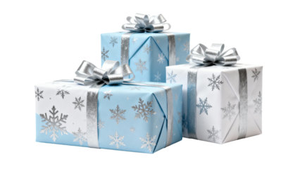 Three beautifully wrapped holiday gifts in blue and white with silver ribbons on a clean background