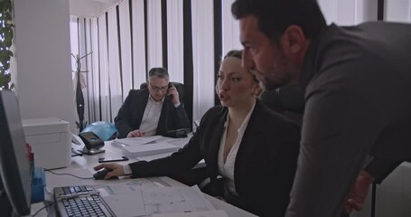 Business colleagues collaborate on a project in an office setting. They discuss work, strategize, and communicate effectively as a team.