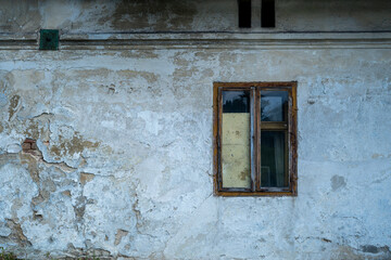 Old weathered wall with rusty wooden window