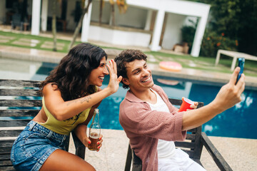 Friends take selfie by pool during sunny day