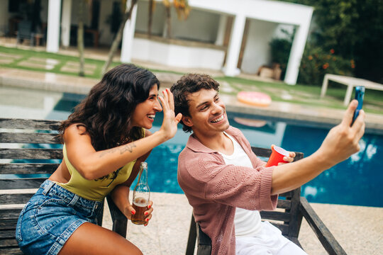Friends take selfie by pool during sunny day