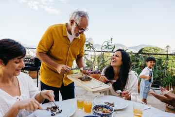 Outdoor Brazilian family enjoying a churrasco gathering with food and smiles