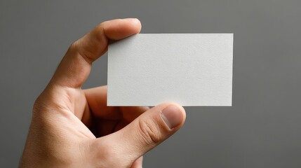 Clean blank business card held in hand for professional networking and brand promotion, showcasing modern design possibilities for corporate identity and marketing materials