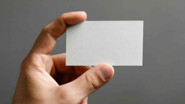 Present your brand with style using this mockup of a hand holding a textured business card, ideal for showcasing your design or logo with a professional and clean aesthetic