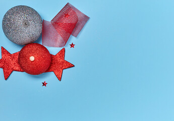 Christmas baubles, stars and ribbons on blue background