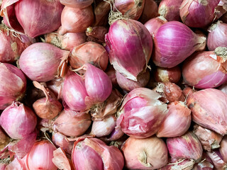 A vibrant closeup of fresh red shallots, showcasing their rich purplered skins and natural textures, essential for adding flavor to many dishes