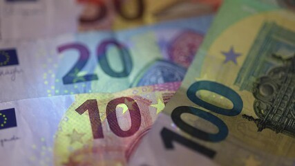 european euro banknotes under UV light, revealing advanced security features and anti-counterfeiting elements. financial banking and economy concept