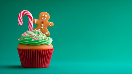 Christmas cupcake with green frosting topped with candy cane and gingerbread man on vibrant green background