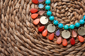 Colorful necklace featuring turquoise beads and vibrant charms on a woven background showcasing craftsmanship and design details