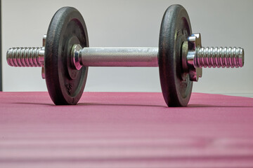 Indoor. A small dumbbell placed on a yoga mat