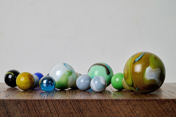 Indoor. Pretty colored marbles on a piece of wood
