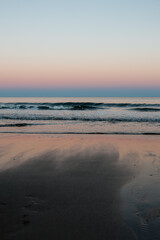 Reflective sunrise light over calm ocean waves