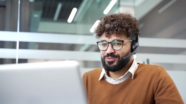 Corporate operator in headset working in customer support service on helpline telesale talking using laptop in business office. Agent of call center advises client, answers questions online. Close up