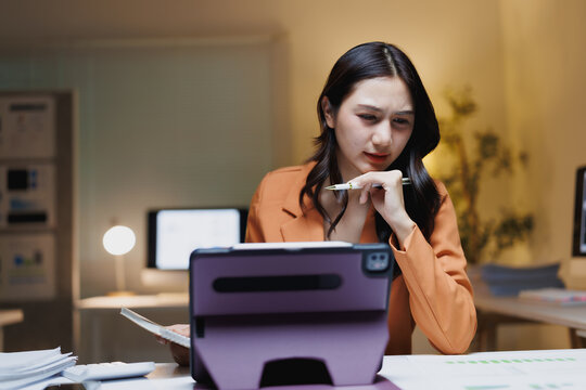 Asian businesswoman concentrating on work late at night