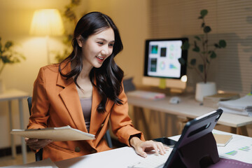 Asian businesswoman smiling while working with tablet in office
