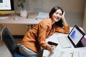 Young businesswoman smiling while analyzing data at office desk