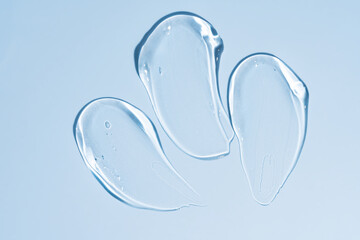 transparent gel texture on a blue background. cosmetic cream stroke, face care gel. Creamy foundation or moisturizer