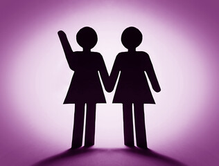 Close up of two paper woman with a raised hand.