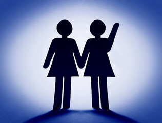 Close up of two paper woman with a raised hand.