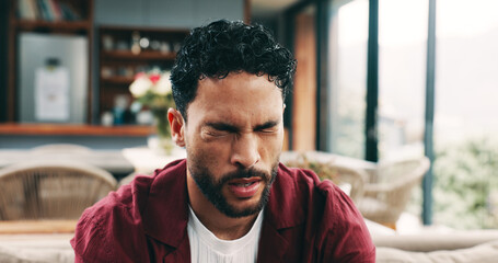 Frustrated man, headache and eye strain with pain on sofa for burnout, fatigue or stress in home....