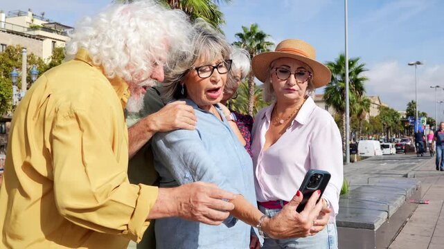 Group of senior friends taking selfie photos with smartphone outdoors - Powered by Adobe