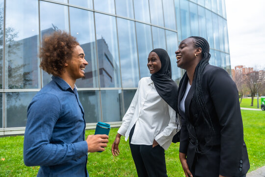 Diverse business colleagues laughing enjoying outdoor break discussing work