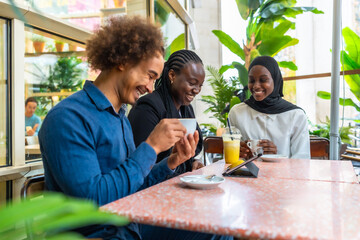 Happy diverse friends laughing together at cafe