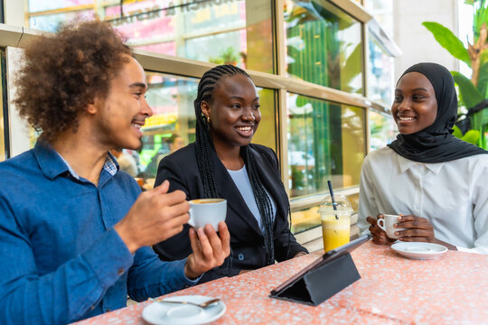 Diverse friends enjoying coffee and conversation at cafe - Powered by Adobe