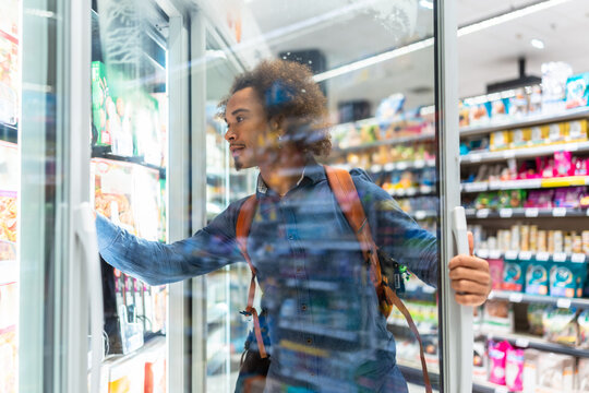 Young black man shopping for frozen food in supermarket